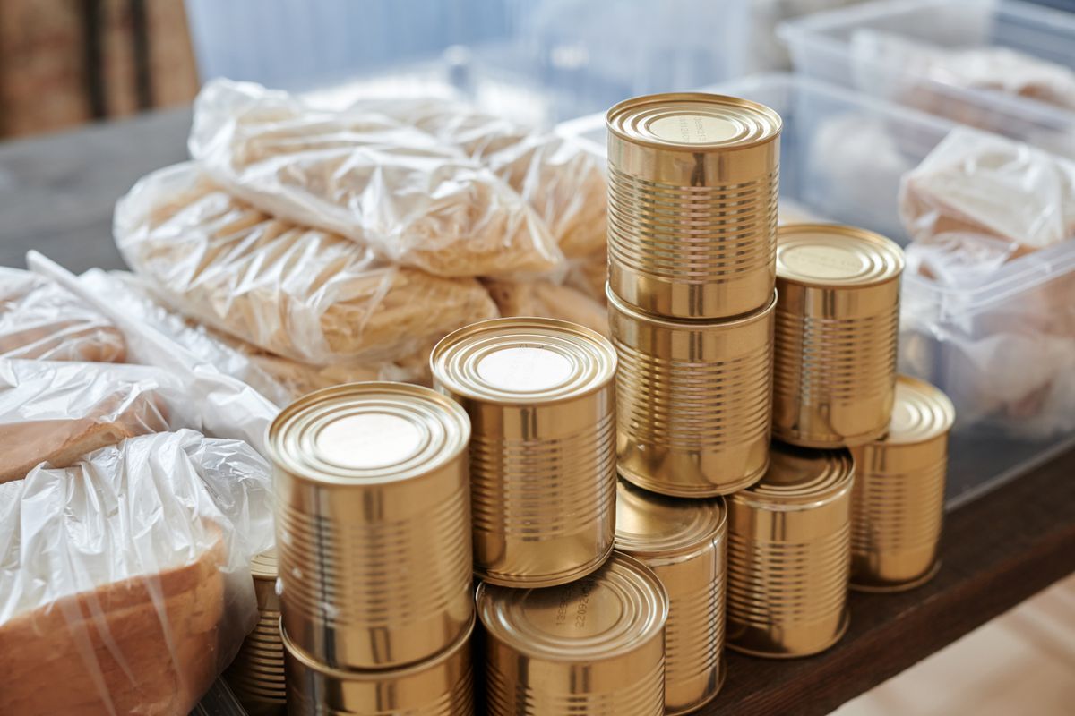 テーブルに積み上げられた缶詰と食品の買いだめストック